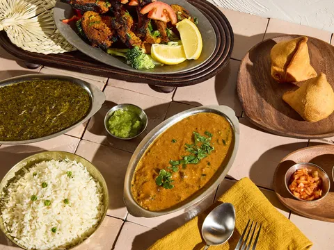 Spread of Indian dishes at Aab India Restaurant including a tandoori platter, saag, dal makhani, basmati rice, samosas and chutneys
