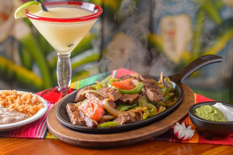 Sizzling beef fajitas with rice, beans and a margarita at Doña Maria Tamales