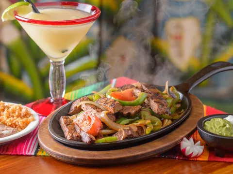 Sizzling beef fajitas with rice, beans and a margarita at Doña Maria Tamales