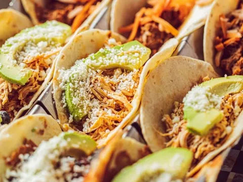 Close-up of tacos topped with avocado and cotija at Blue Habanero