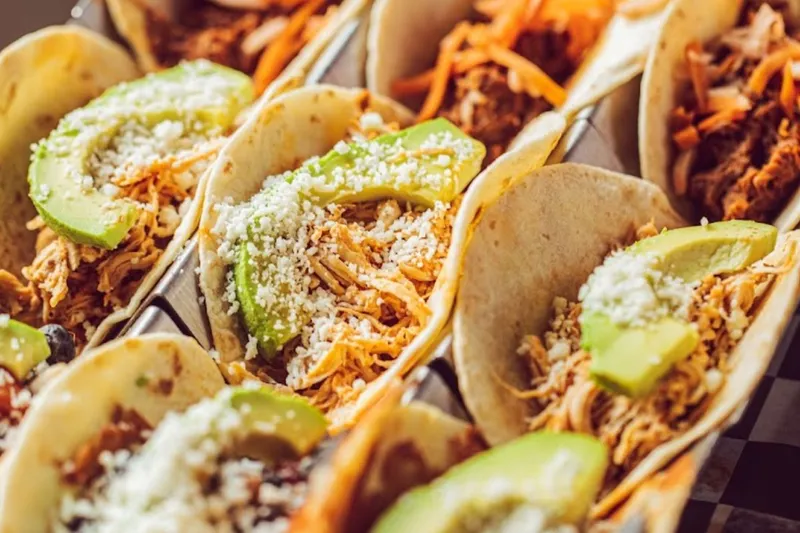 Close-up of tacos topped with avocado and cotija at Blue Habanero