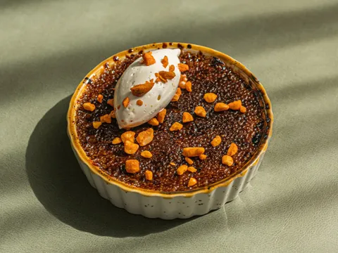 Crème brûlée dessert with spiced pecan crumble and quenelle of cream at Common Thread in Savannah
