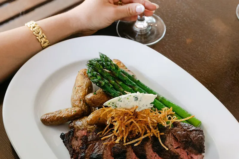 Sliced steak with roasted potatoes and asparagus at The Corner Kitchen