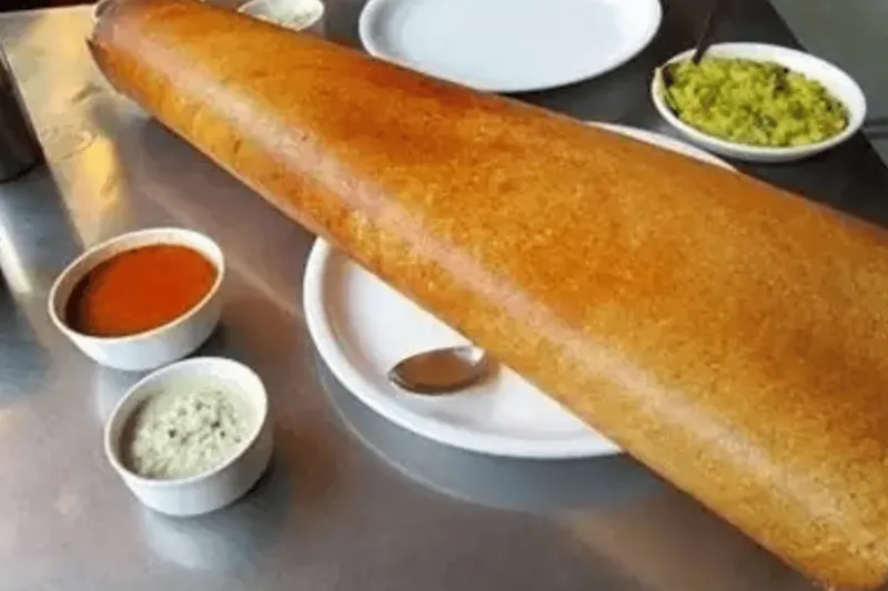 A large crispy dosa served with sambar and coconut and tomato chutneys at Samburna Indian Restaurant in Bothell