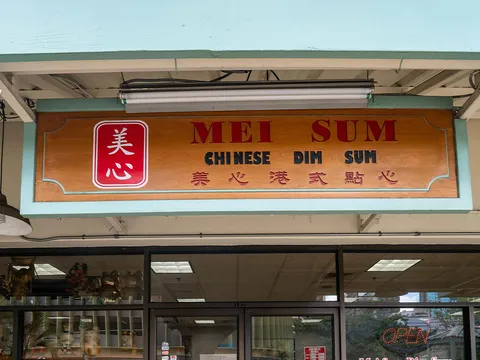 The carved wooden Mei Sum Chinese Dim Sum storefront sign above the restaurant's window in Honolulu Chinatown