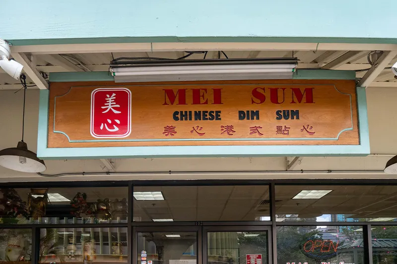 The carved wooden Mei Sum Chinese Dim Sum storefront sign above the restaurant's window in Honolulu Chinatown