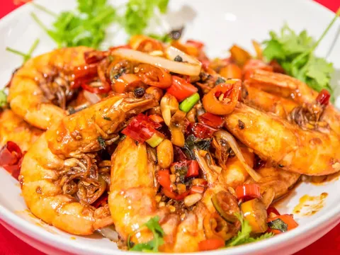 House-special spicy sautéed shrimp with red chilies, peppers and cilantro on a white plate at Red Chili Hunan Restaurant