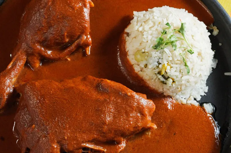 Plate of mole negro with chicken and rice at Guelaguetza
