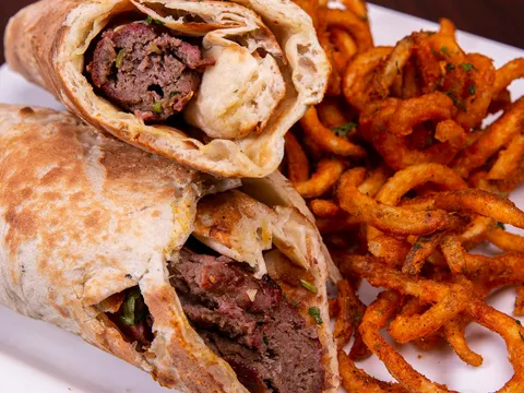 Sliced kabob wrap with a side of spiced curly chaat fries at Tandoor Char House in Chicago
