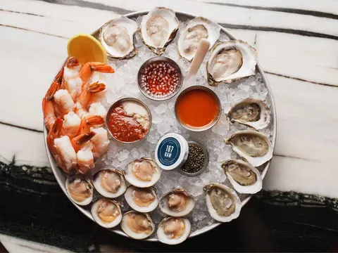 Overhead seafood tower at 167 Raw Oyster Bar with oysters, little neck clams, jumbo shrimp, caviar and dipping sauces on crushed ice