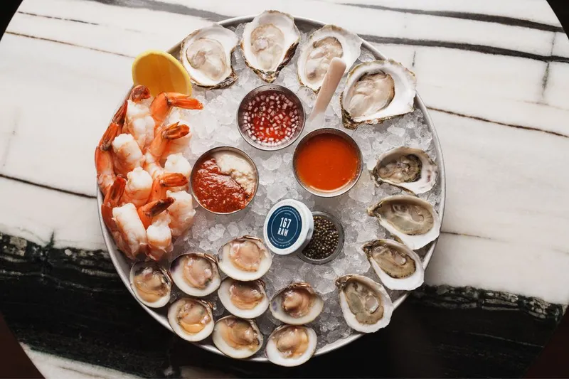 Overhead seafood tower at 167 Raw Oyster Bar with oysters, little neck clams, jumbo shrimp, caviar and dipping sauces on crushed ice