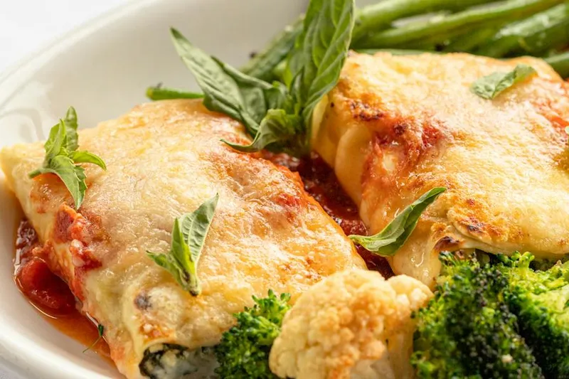 Baked manicotti with melted cheese, tomato sauce, broccoli, cauliflower and basil at Lidia's Kansas City.