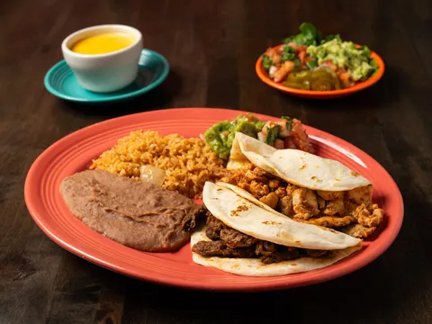 Fajita taco plate with beef and chicken fajita flour tacos, Mexican rice, refried beans and guacamole at Henry's Puffy Tacos
