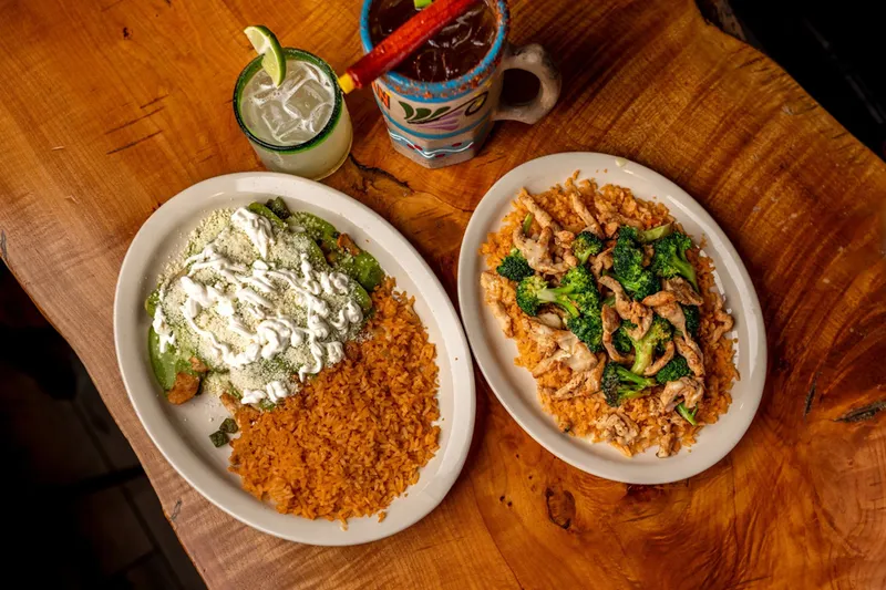 Two entree plates with rice and a drink at Cilantro Mexican Grill