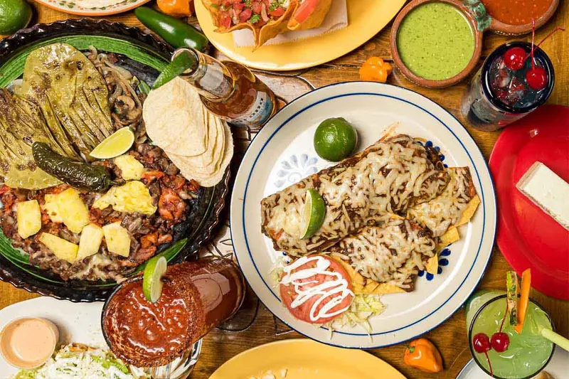 Spread of Los Guachos tacos, sopes, al pastor with pineapple, enchiladas and salsas
