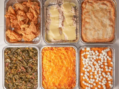 Family-style trays of fried chicken, collard greens, mac and cheese and candied yams at Mary Mac's Tea Room
