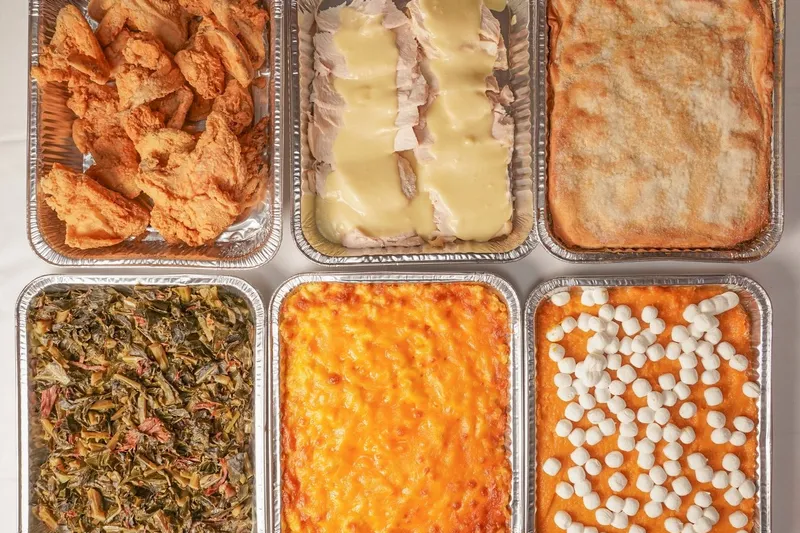 Family-style trays of fried chicken, collard greens, mac and cheese and candied yams at Mary Mac's Tea Room