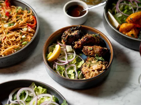 Hakka noodles, tandoori chicken and sides plated at Mumbai Central