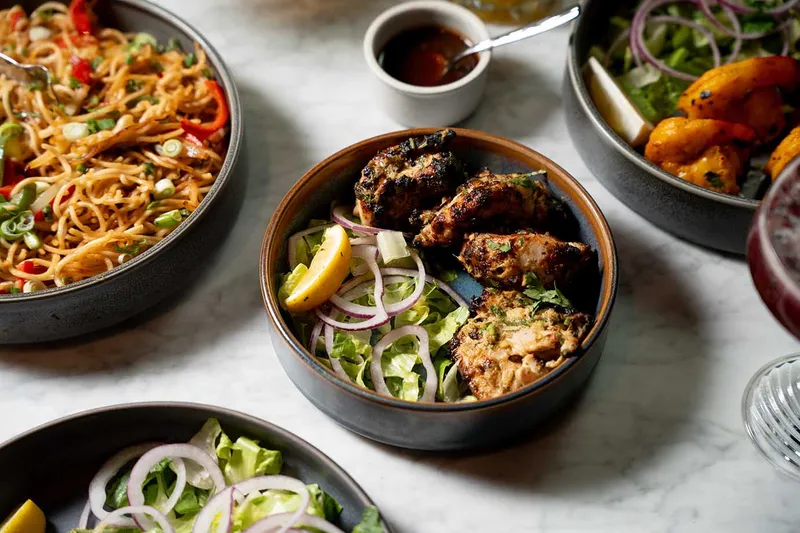 Hakka noodles, tandoori chicken and sides plated at Mumbai Central
