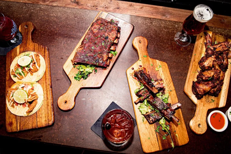 Overhead spread of ribs, wings, tacos and cocktails at Hammerheads