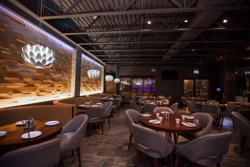 Dining room with lotus-shaped pendant lights and wood tables at Dolo Restaurant & Bar in Chicago's Chinatown
