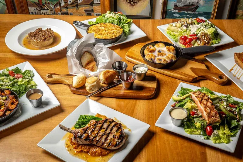 Steaks, salads and sides spread across a table at Crazy Cat Eat Up