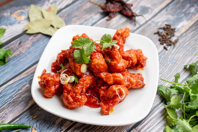 A plate of sauced vegetable appetizer from Woodlands Indian Vegetarian Cuisine.