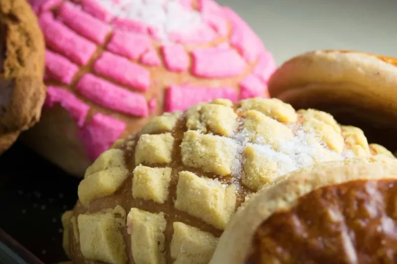 Close-up of Mexican pan dulce (conchas) — pink and vanilla sugar-crusted sweet breads — from the bakery at Esperanza's in Fort Worth