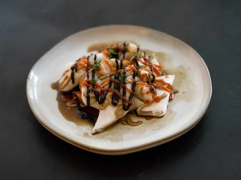 Plate of steamed rice rolls (ji cheung fun) drizzled with hoisin, sesame and chili sauce and topped with scallions at Rubato HK Cafe in Quincy