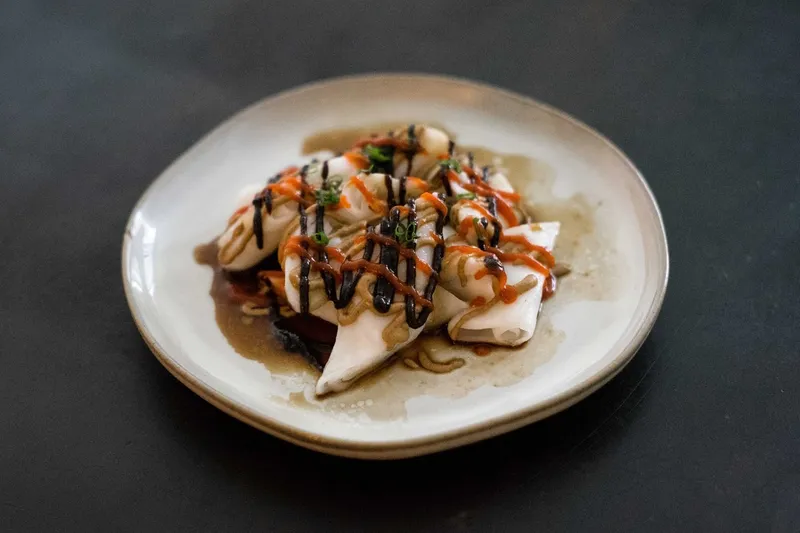 Plate of steamed rice rolls (ji cheung fun) drizzled with hoisin, sesame and chili sauce and topped with scallions at Rubato HK Cafe in Quincy