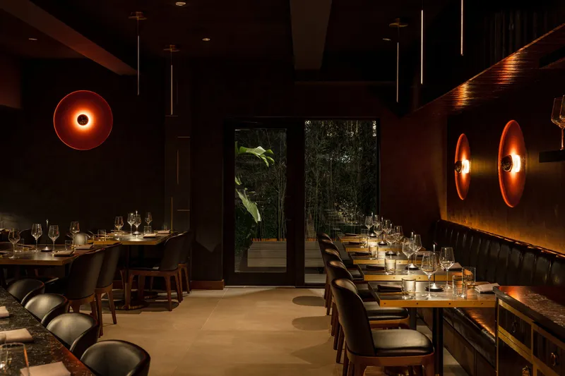 Dimly lit dining room with a long banquette at Yingtao