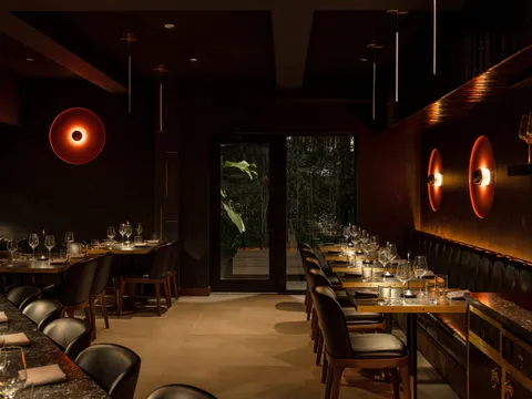 Dimly lit dining room with a long banquette at Yingtao