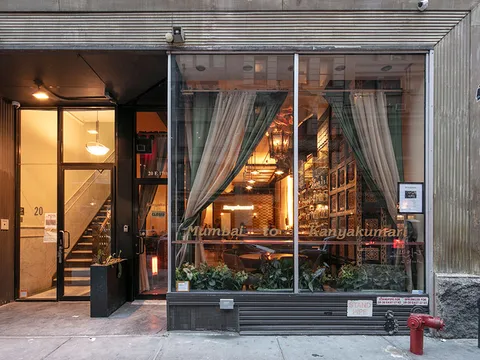 Evening view of Kanyakumari's Union Square storefront on East 17th Street, with 'Mumbai to Kanyakumari' lettering across the front windows and a warmly lit dining room inside