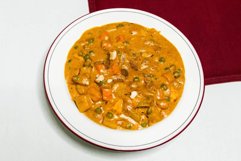 Navrattan Korma — mixed vegetables and cashews in a cream sauce on a bordered plate at India Gate in Bellevue