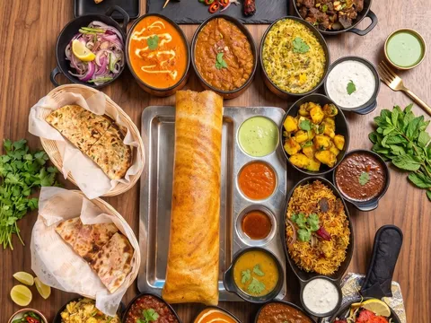 Overhead spread of a dosa, curries, kebabs and chutneys at Mint Indian Bistro