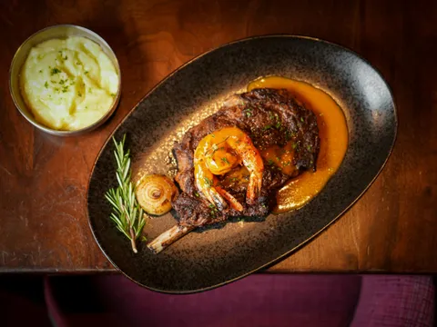 Limón rotisserie chicken plated with sauce and mashed potatoes