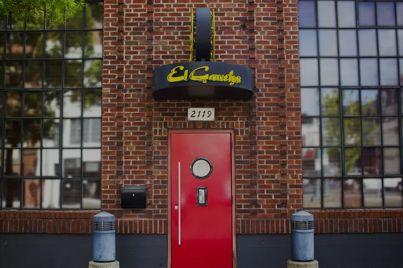 Brick exterior and red entrance door of El Gaucho Tacoma