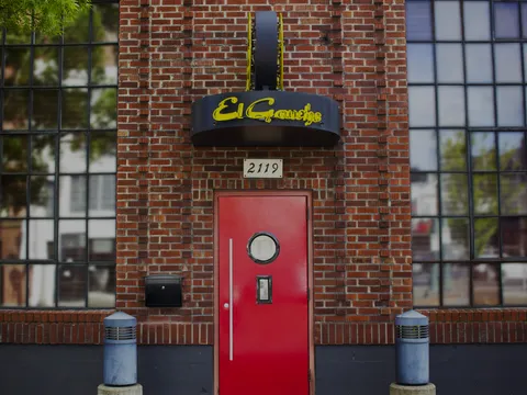 Brick exterior and red entrance door of El Gaucho Tacoma
