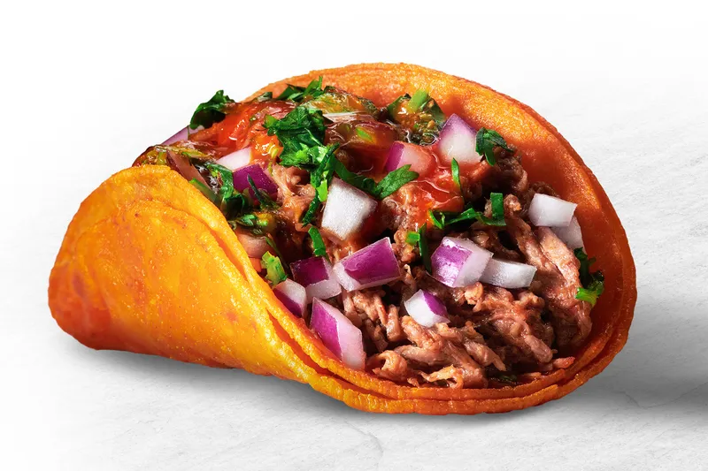 A single Teddy's Red Tacos beef birria taco on a red-tinted crispy corn tortilla topped with diced onion, cilantro and salsa
